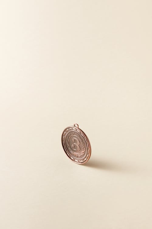 Bronze Round Coin on Beige Surface