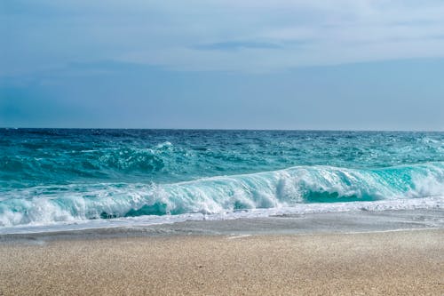 Turquoise Sea Waves Splashing on Sand Beach