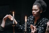 A Woman Wearing Black Printed Long Sleeves Near Burning Candles