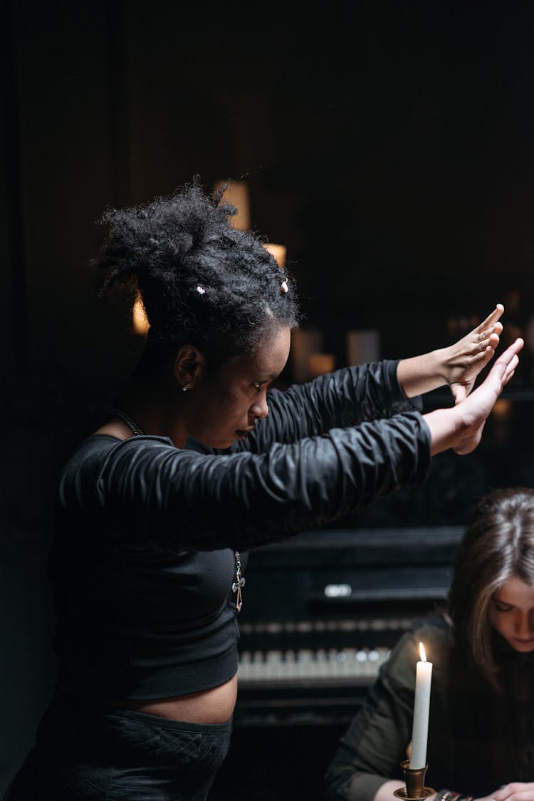 A Woman In Black Long Sleeves Doing Rituals