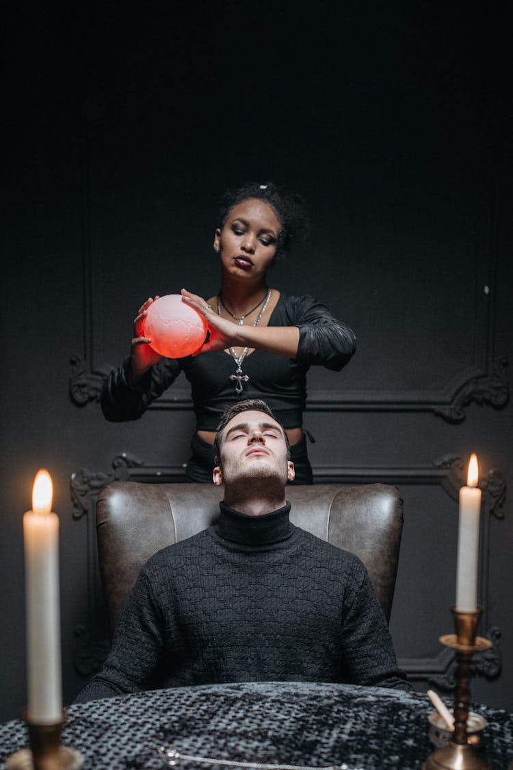 A Woman Holding A Round Object Over A Man's Head