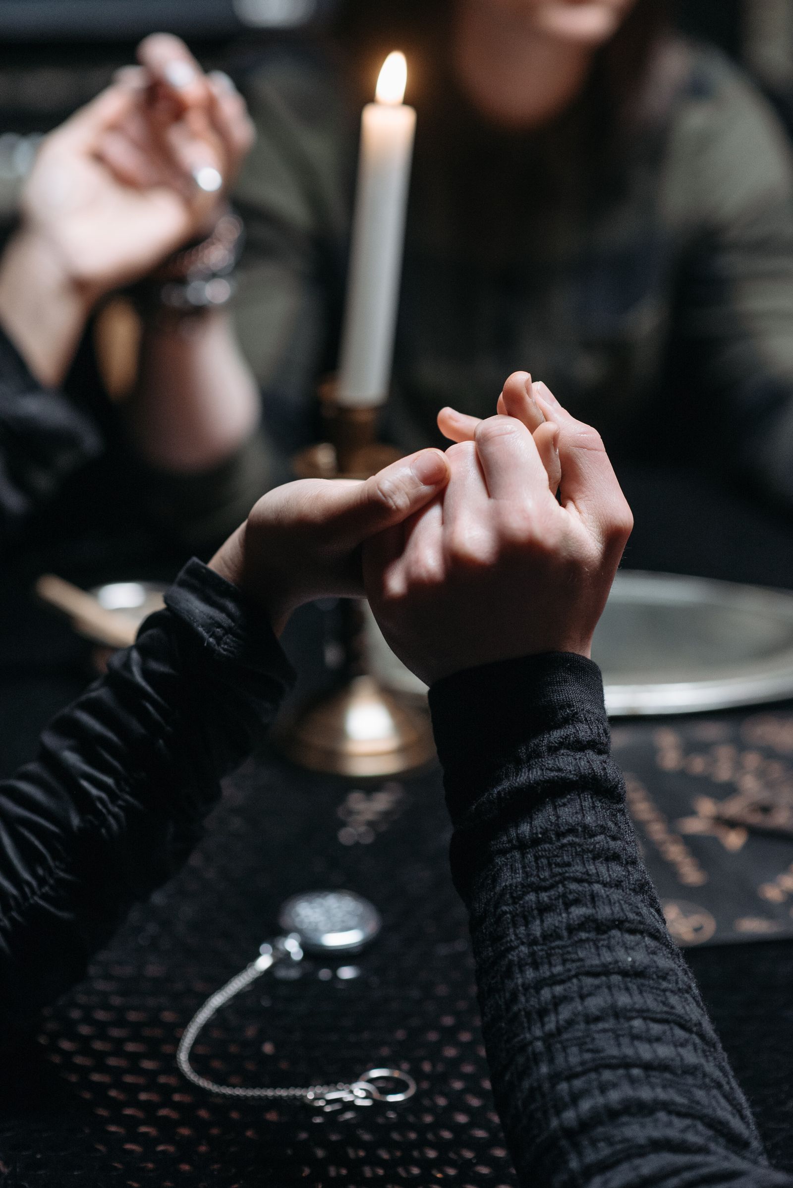 People holding hands near candlelight as a symbol of care, reflection and support