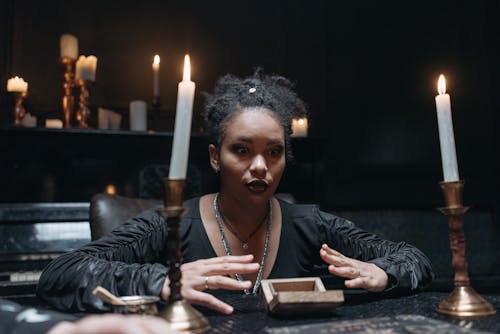 Free Woman Seeing a Spirit in a Dark Room with Candles Stock Photo