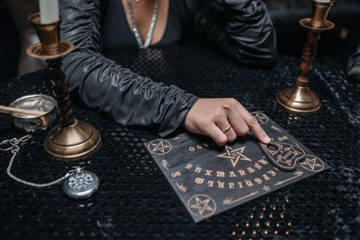 Woman in Black Long Sleeves Using an Ouija Board