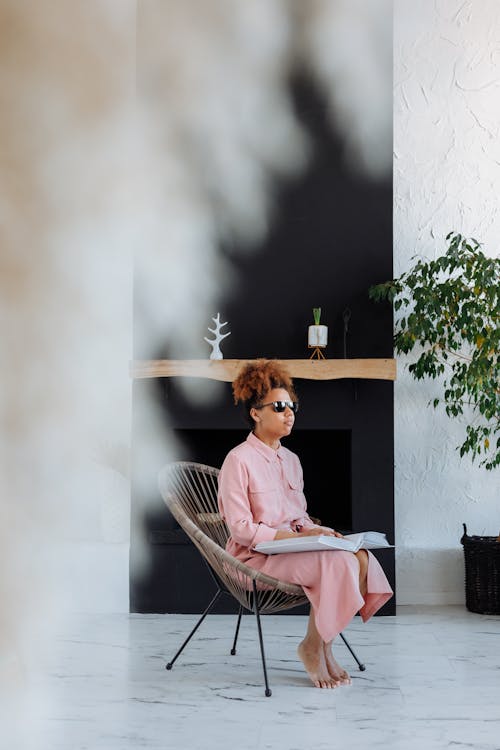 Woman in Pink Dress Sitting on Brown Wooden Chair