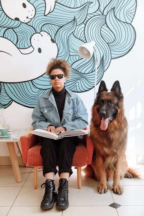 Woman Sitting on Chair Beside a Dog