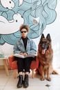 Man in Gray Suit Jacket Sitting Beside Brown Long Coated Dog