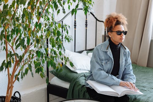 Person Sitting on Bed While Using a Braille