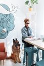 Woman in Blue Denim Jacket Sitting Beside Brown and Black German Shepherd