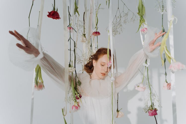 A Woman Wearing White Dress With Hanging Flowers