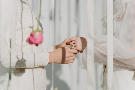 Close-up of a tender wedding vow exchange between two individuals, highlighting delicate flowers.