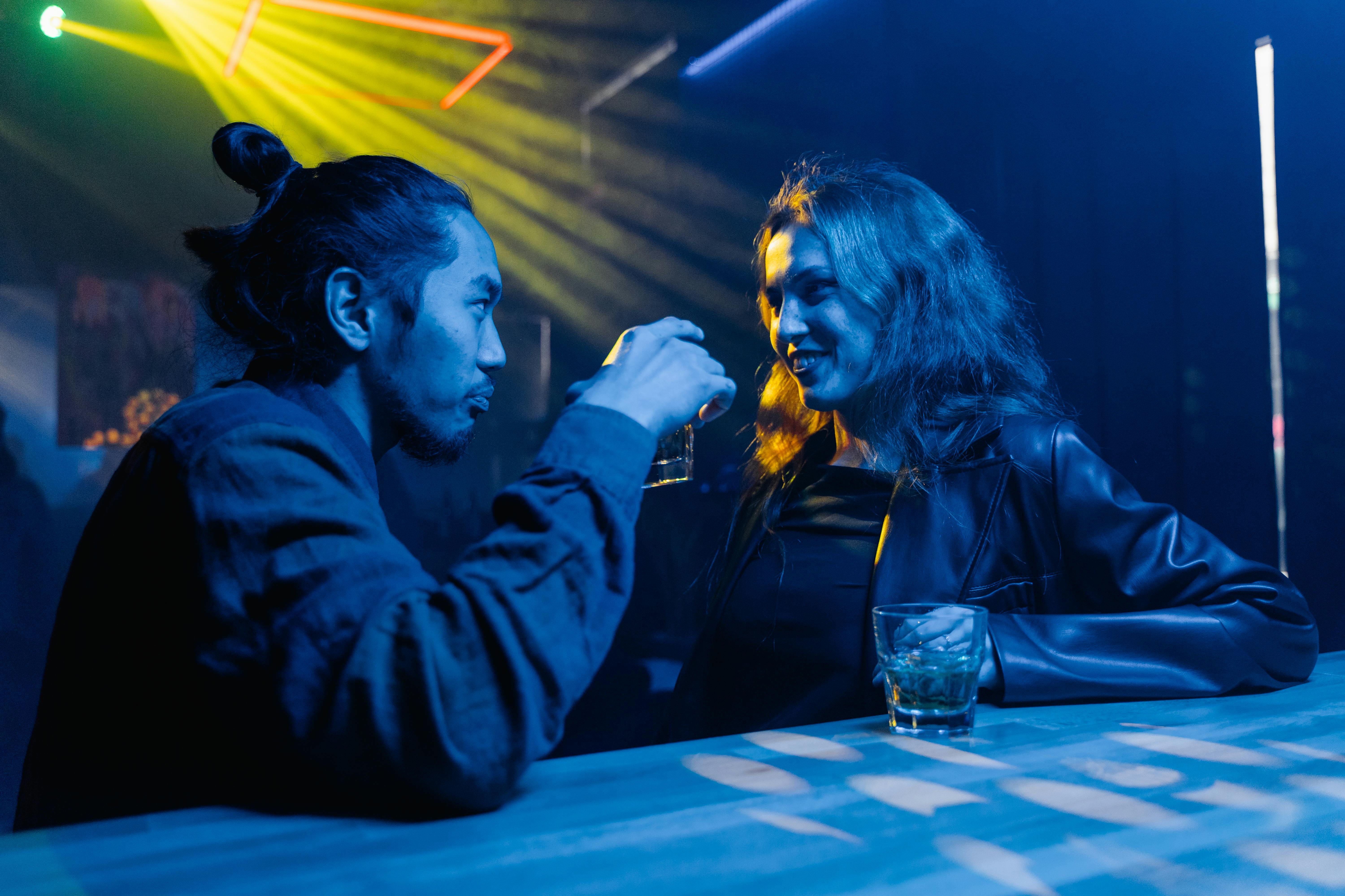 photo of a man and a woman looking at each other at the bar