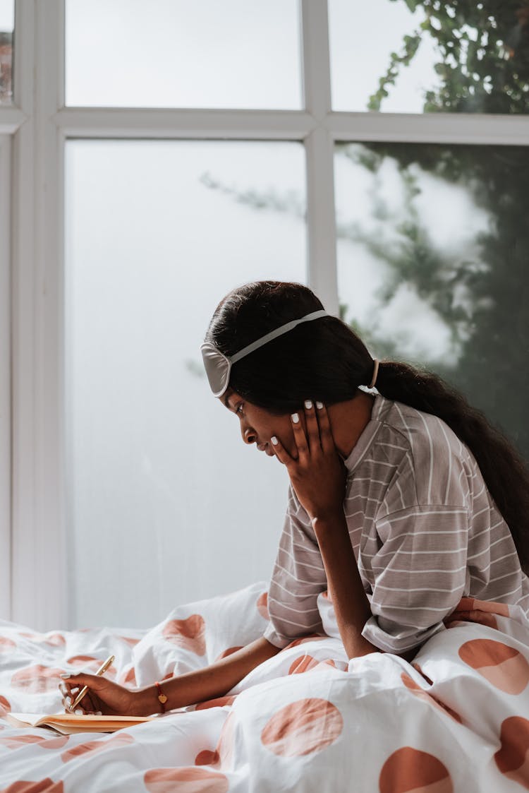 Woman In Pyjama Writing In Bed