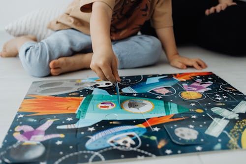 Photograph of a Kid Solving a Jigsaw Puzzle