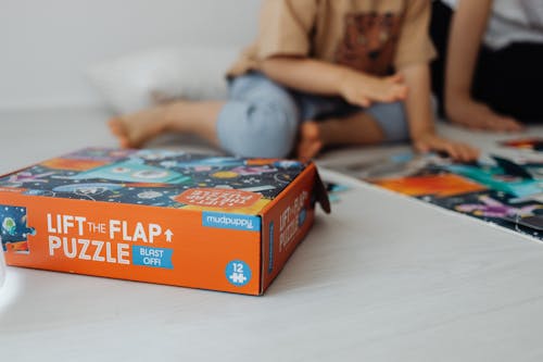 Selective Focus Photograph of a Jigsaw Puzzle Box