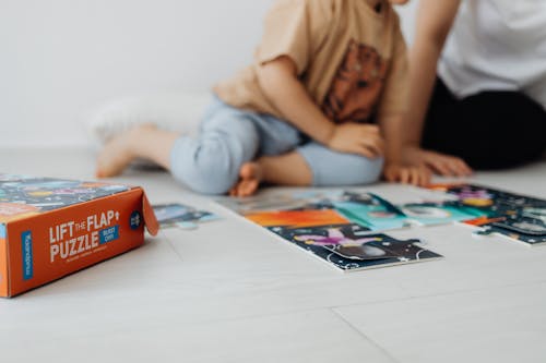 Close-up of Child Sitting on Floor Playing Game