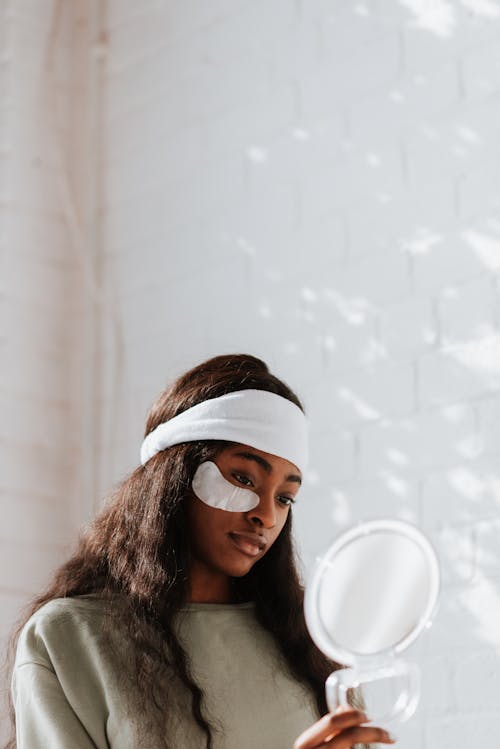 Free Ethnic woman with eye patch on face against mirror Stock Photo