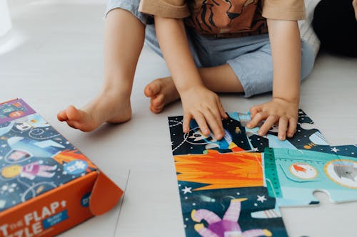 A Child Playing With Blue and Green Puzzle