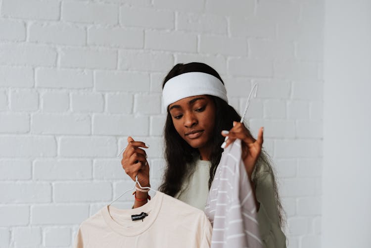 Black Woman In Headband Choosing Clothes Indoors