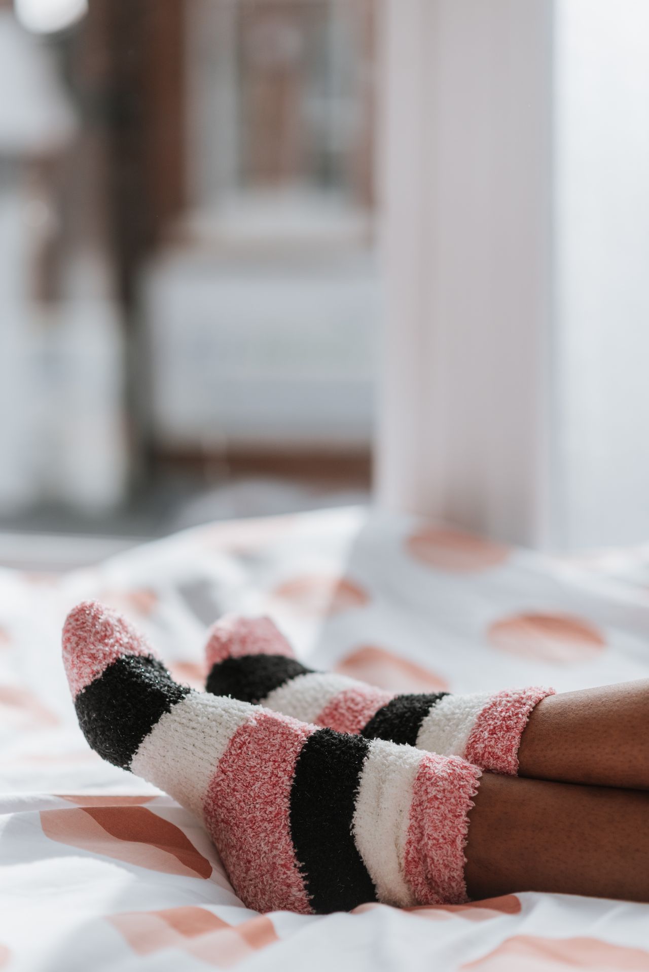 Feet in cozy striped fuzzy winter socks