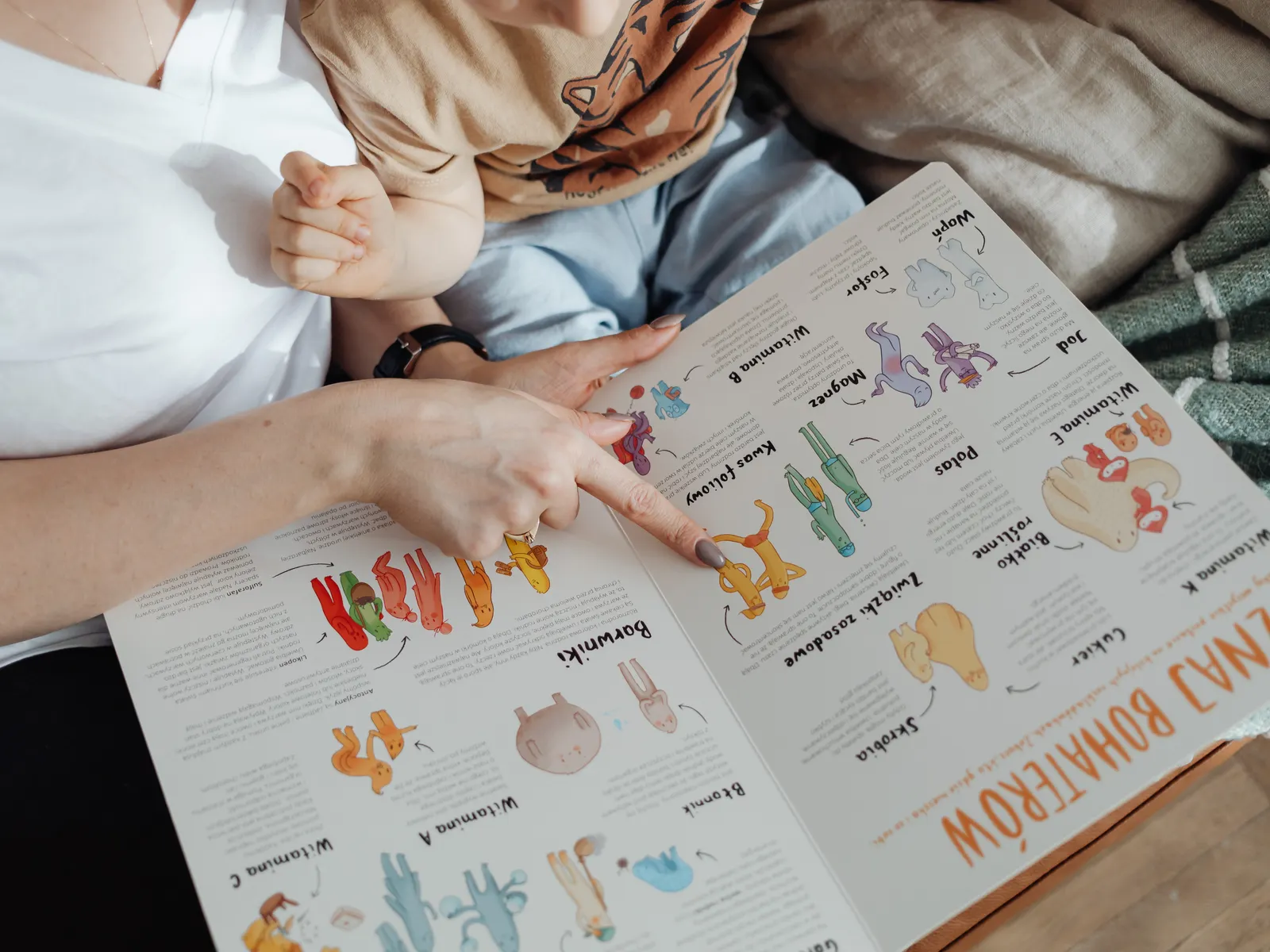 Mother reading a colorful picture book with her baby in a cozy moment