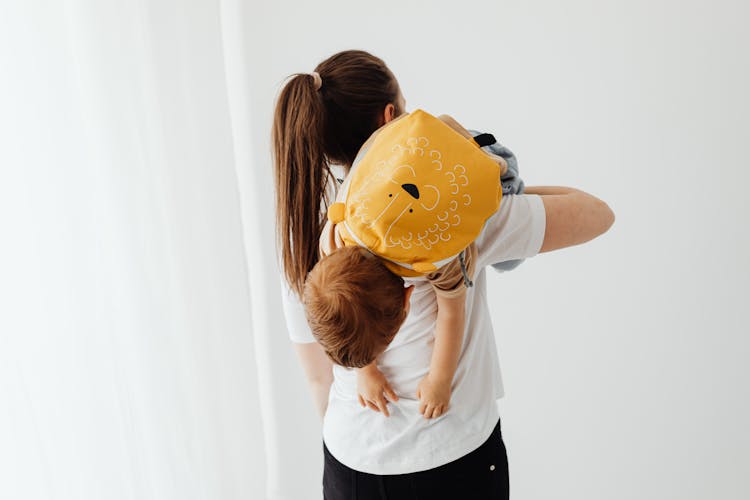 Woman Carrying A Child With A Backpack