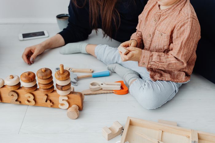 Parent and child playing with wooden toys together