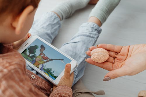 Photo of a Kid Watching on a Cell Phone