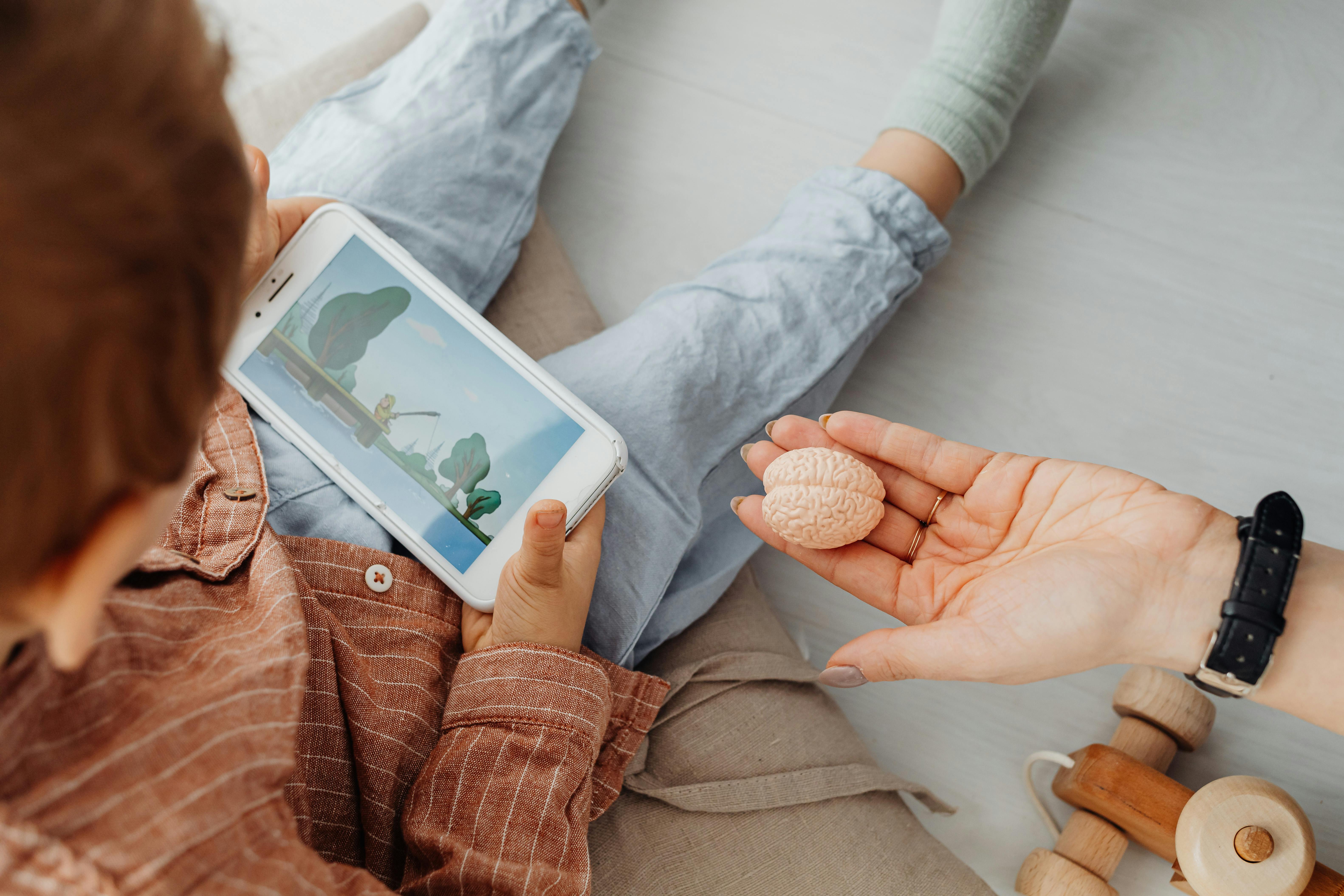 a person s hand near a kid holding a smartphone