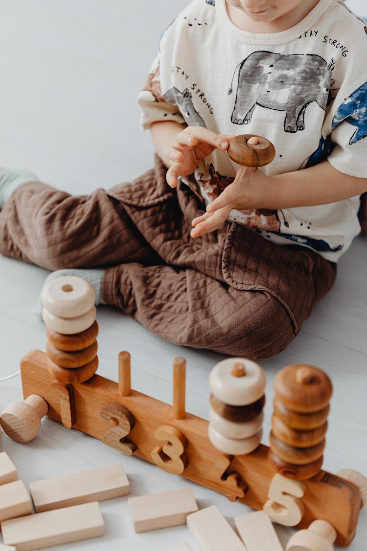 Child Playing With Wooden Game