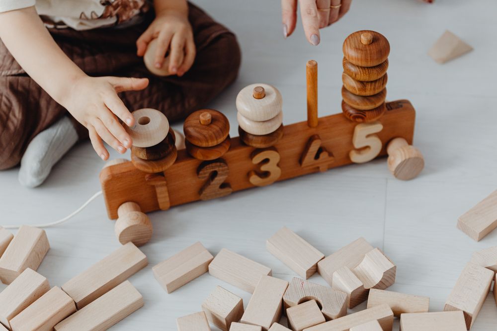 Small hands stacking a wooden number puzzle