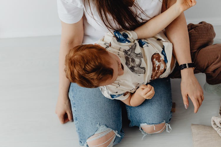 Photo Of A Kid With Red Hair On A Person's Lap