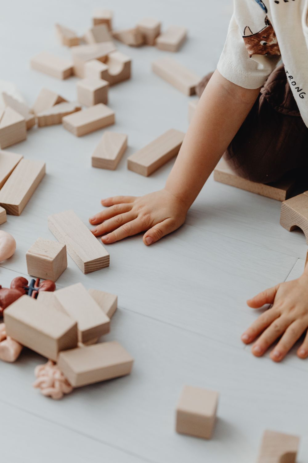 Enfant développant sa dextérité avec des jouets Montessori pour la motricité fine en bois.