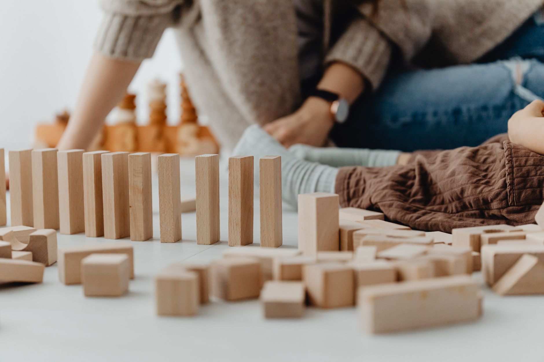 A child playing with wooden blocks indoors, focusing on development and creativity.