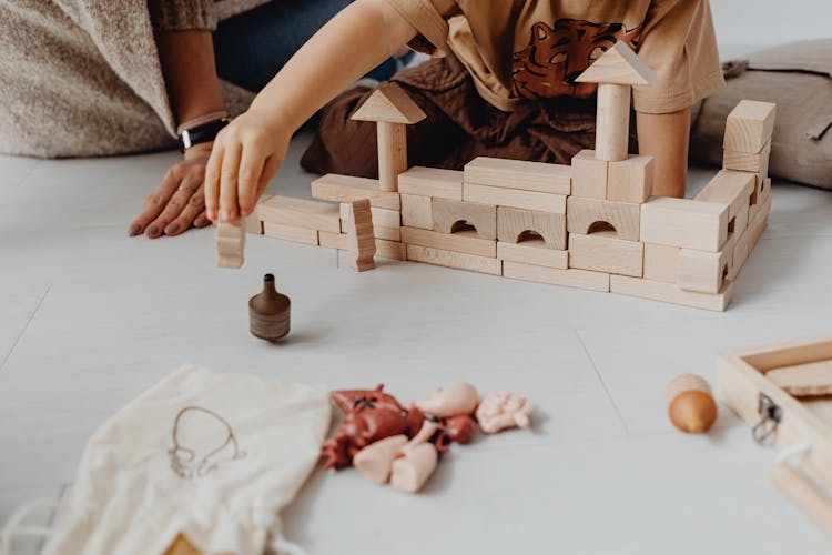 Child Playing With Toy Blocks On Floor