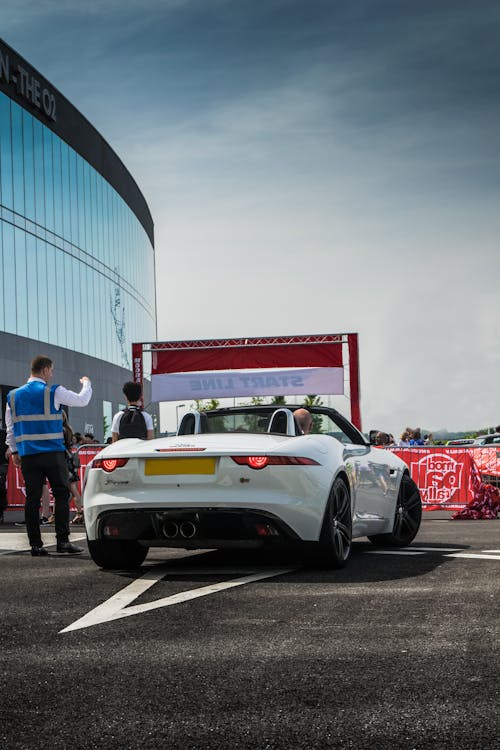 A White Jaguar F Type Luxury Car Parked on Asphalt Road