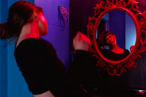 A Woman Looking at a Wall Mirror