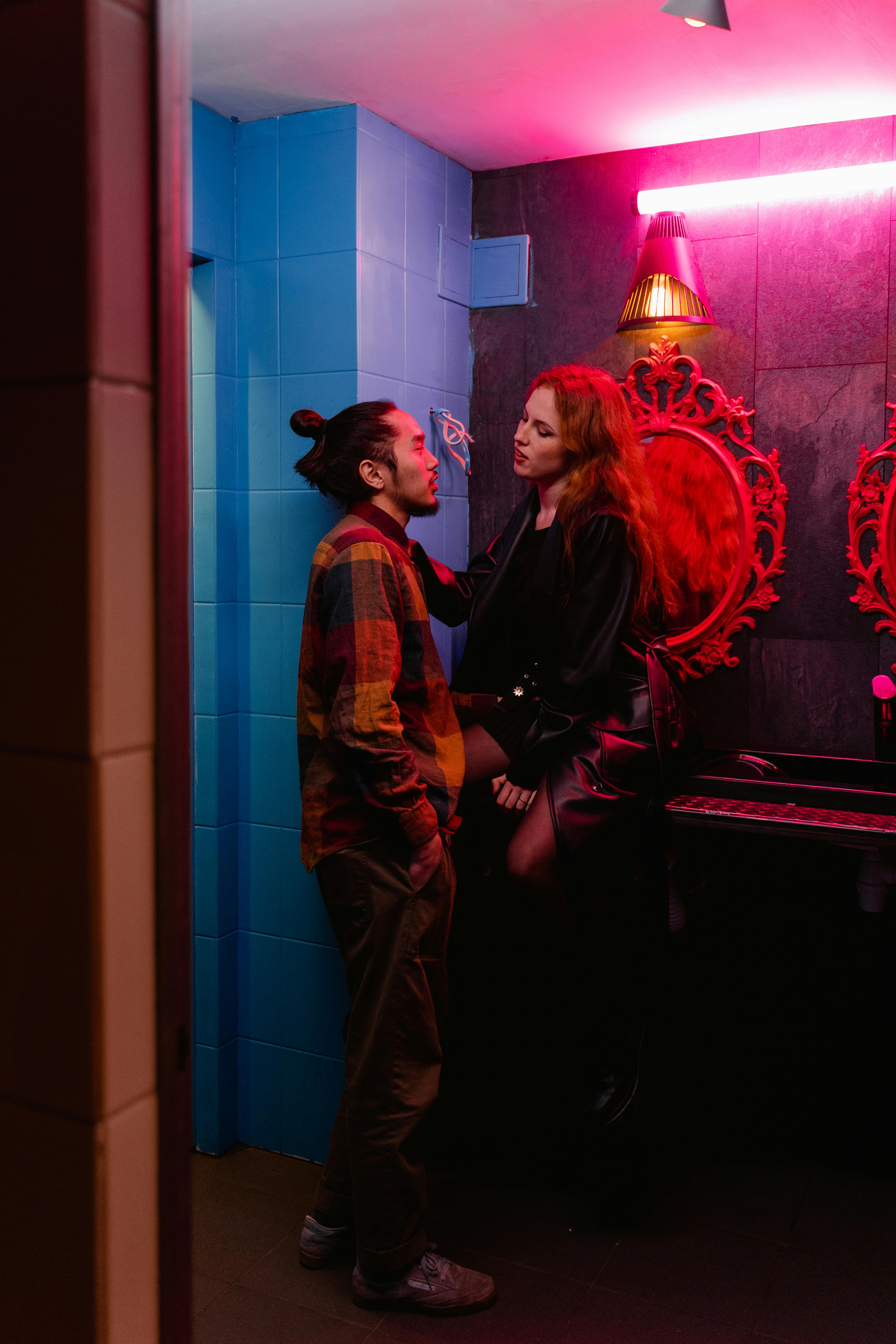 man and woman standing beside red and white wall