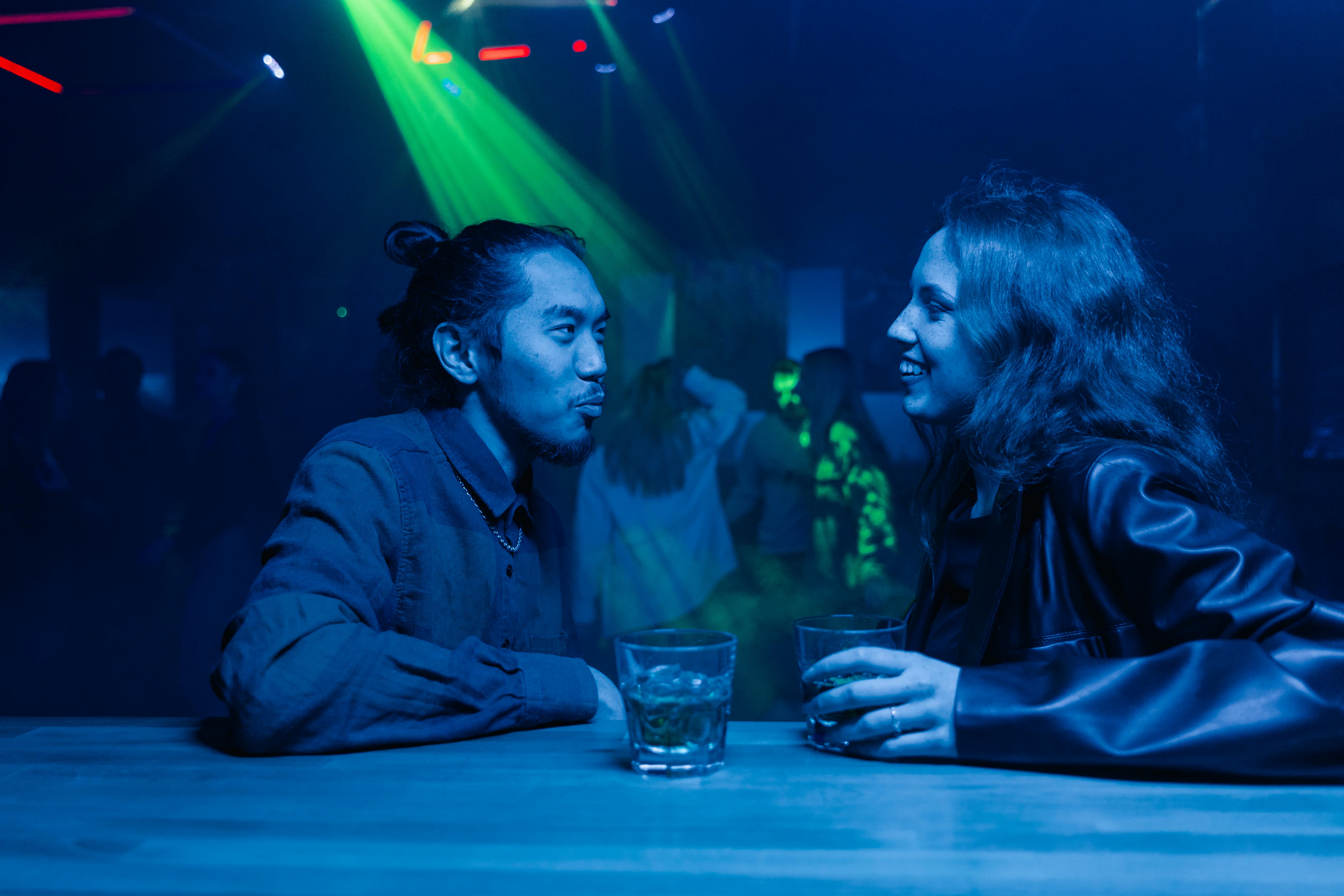 photo of a man talking to a woman in a leather jacket