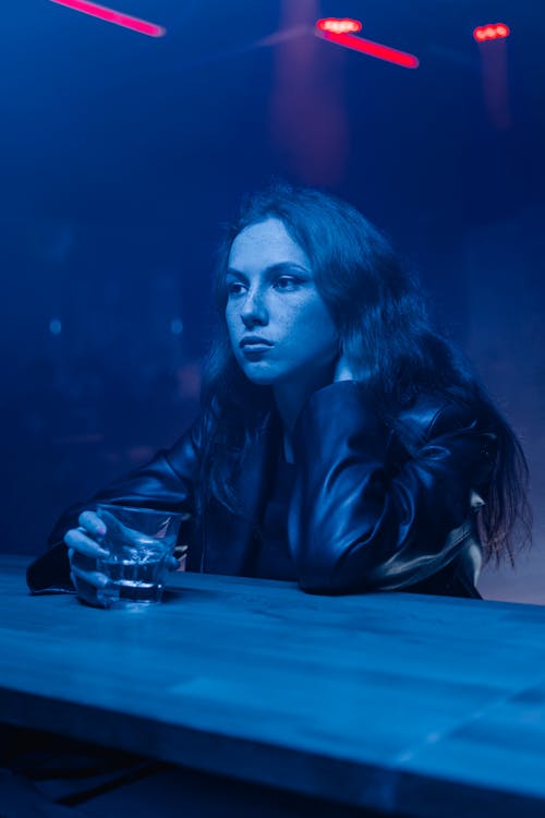 Woman in a Leather Jacket Holding a Glass of an Alcoholic Drink