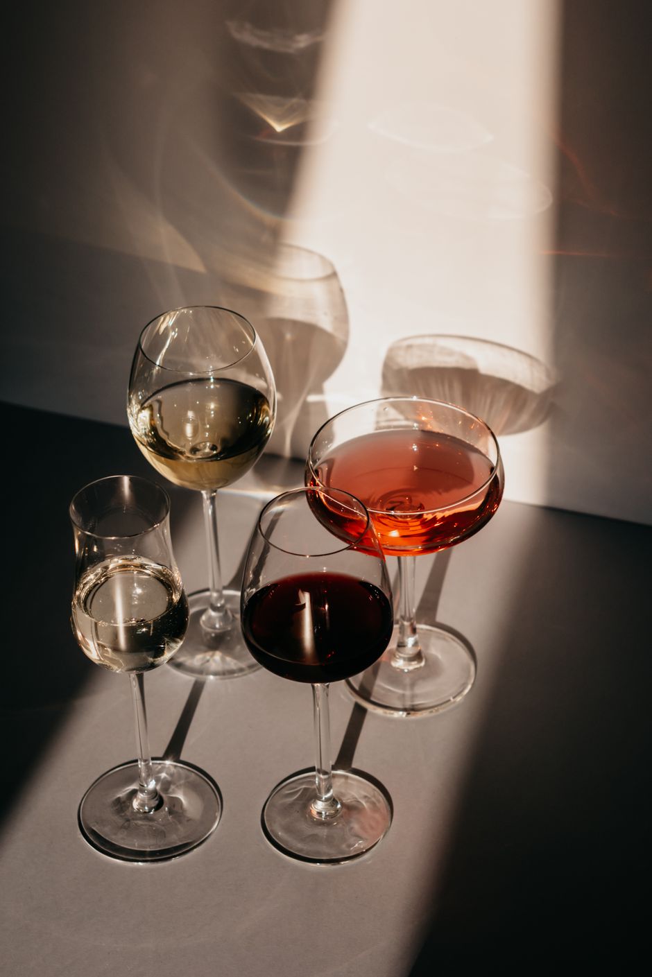 A sophisticated display of various glasses filled with wine under soft, ambient lighting.