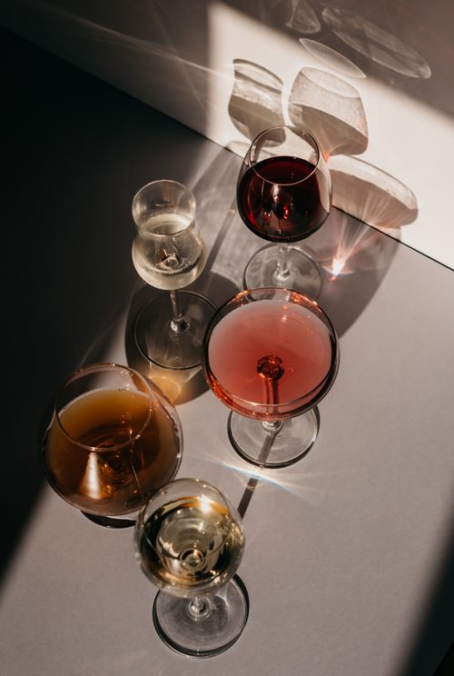 Free A sophisticated still life of wine glasses casting shadows under sunlight, ideal for luxurious event themes. Stock Photo