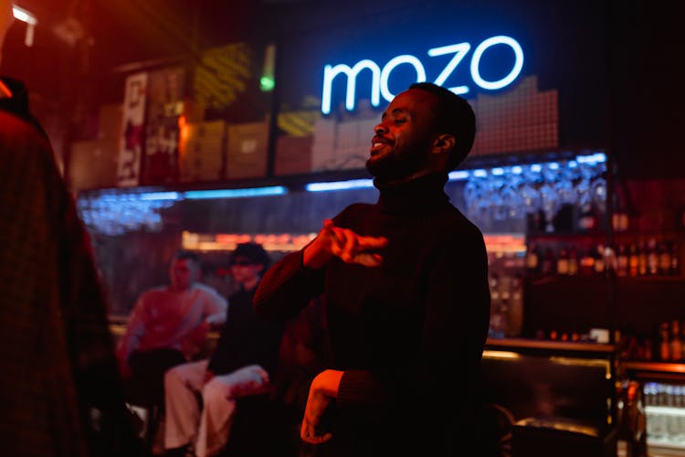 Man Wearing A Sweater Dancing Inside The Nightclub