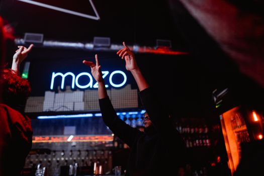 Energetic nightclub atmosphere with people dancing and hands raised, capturing the essence of nightlife.
