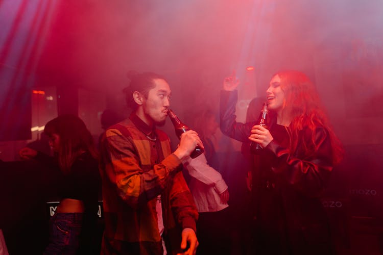 A Man And Woman Partying At The Club While Drinking Beer