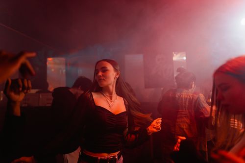 Free Energetic party scene showing people dancing in a colorful nightclub atmosphere. Stock Photo