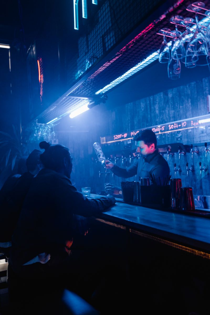 Bartender mixing drinks in a dim stylish bar