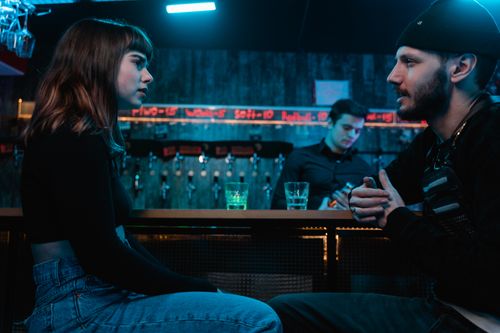 Free A group of young adults conversing and enjoying drinks at a stylish bar. Stock Photo