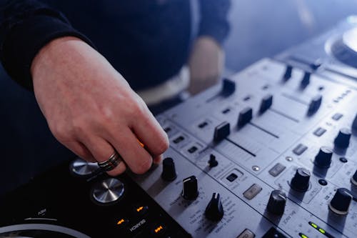 Close-Up Shot of a DJ Using a Mixing Console