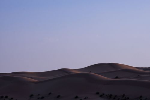 Free Calm desert dunes under a clear twilight sky, offering tranquility and natural beauty. Stock Photo